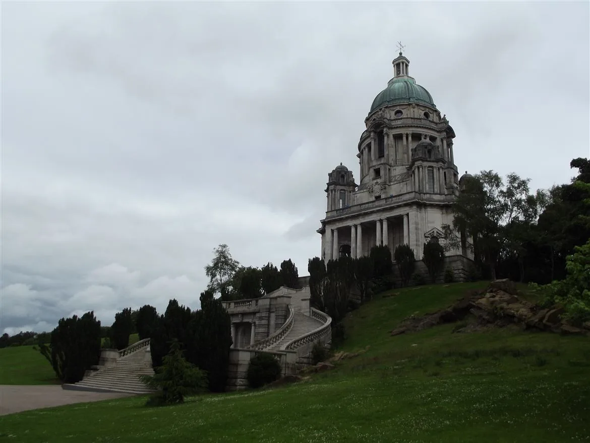 The Ashton Memorial's green copper dome rising above the trees and lawns of Williamson Park