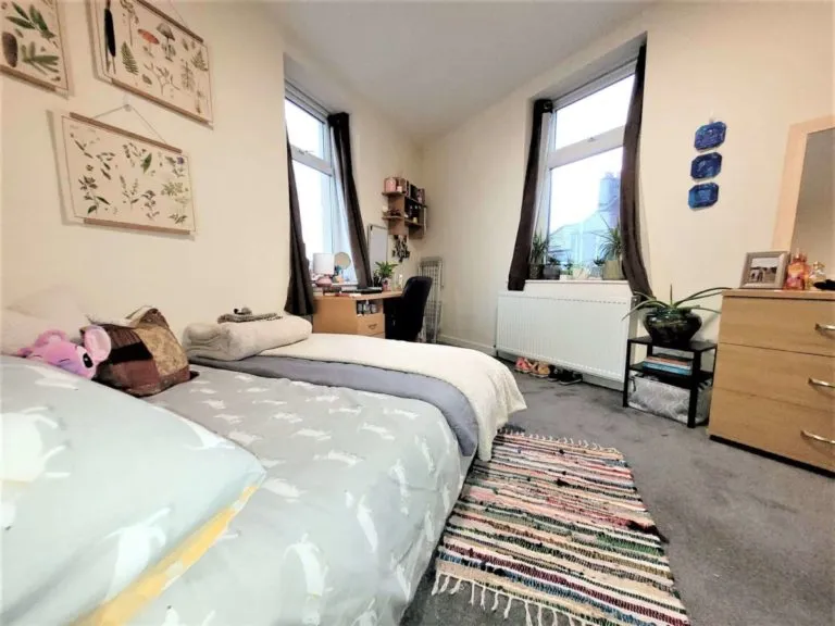 Furnished Gregson Road student bedroom with double bed, desk, storage and two windows